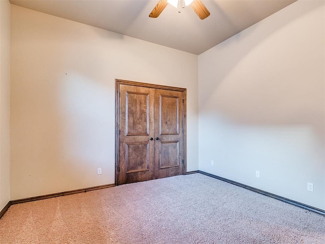 unfurnished room with light colored carpet and ceiling fan