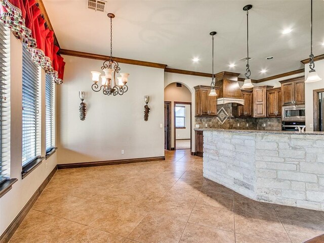 kitchen featuring visible vents, custom exhaust hood, arched walkways, appliances with stainless steel finishes, and backsplash