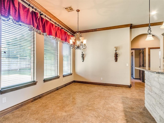 spare room with visible vents, crown molding, baseboards, an inviting chandelier, and arched walkways