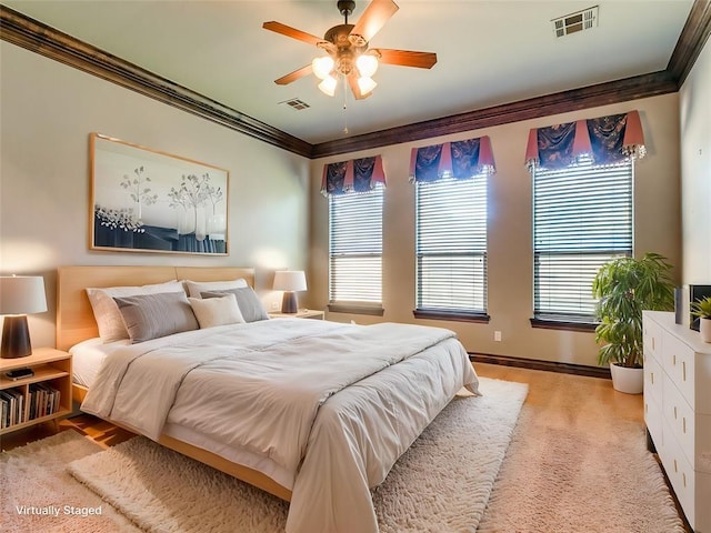 bedroom featuring a ceiling fan, light colored carpet, visible vents, and ornamental molding