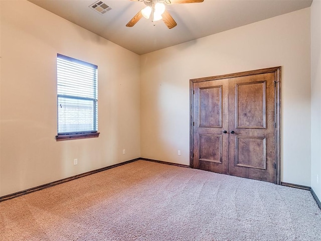 unfurnished bedroom featuring visible vents, a ceiling fan, baseboards, and carpet floors