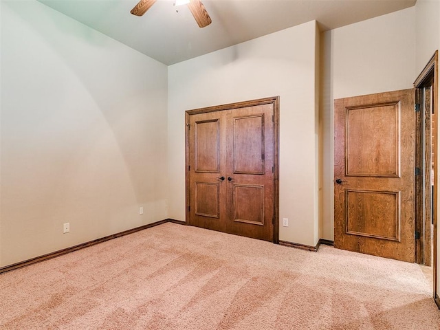 unfurnished bedroom with carpet flooring, baseboards, and ceiling fan