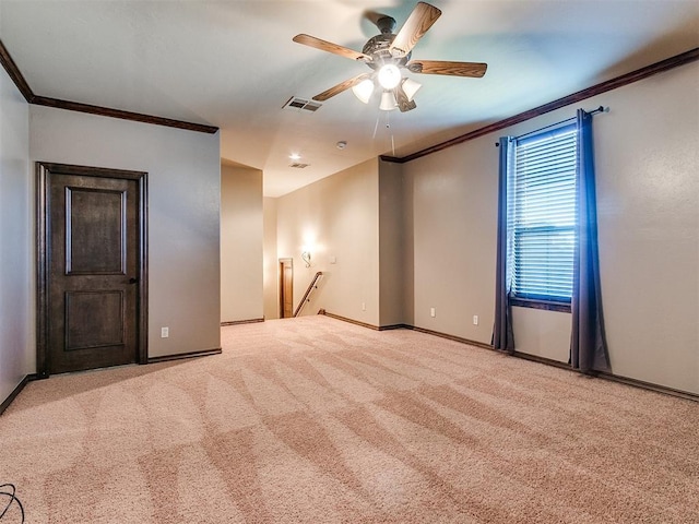 carpeted empty room with baseboards, visible vents, and ornamental molding