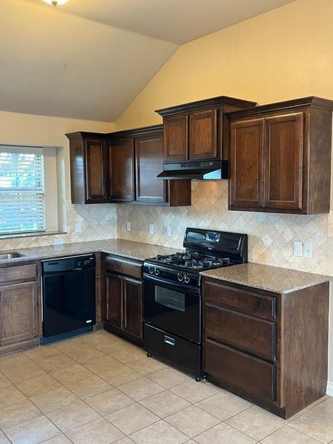 kitchen featuring decorative backsplash, light stone counters, vaulted ceiling, and black appliances