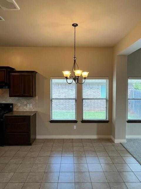 kitchen featuring dark brown cabinetry, black electric range, a notable chandelier, decorative light fixtures, and light tile patterned flooring