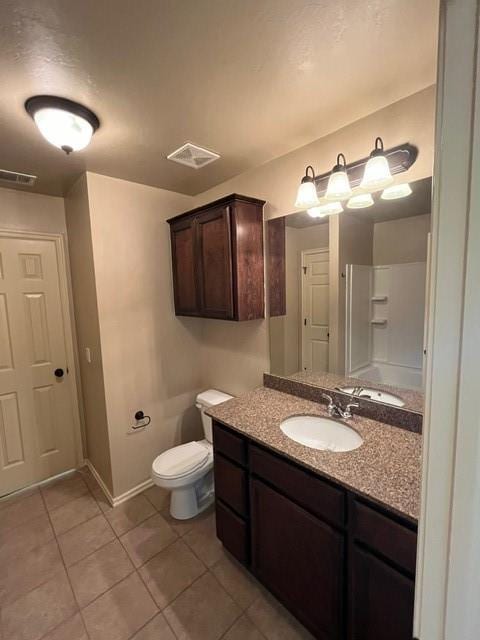 bathroom featuring tile patterned flooring, vanity, and toilet