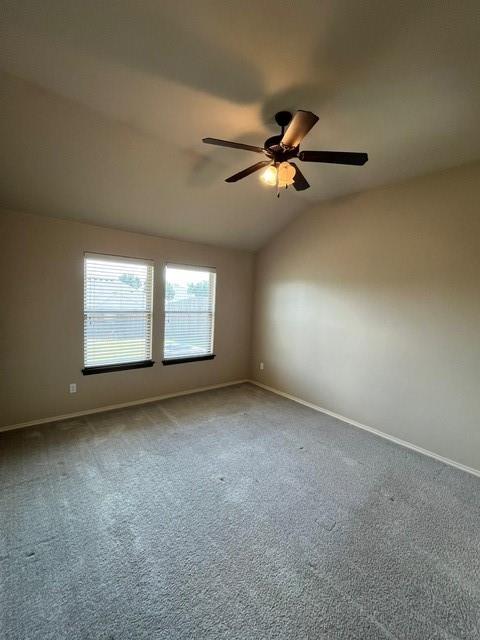 unfurnished room with carpet floors and vaulted ceiling