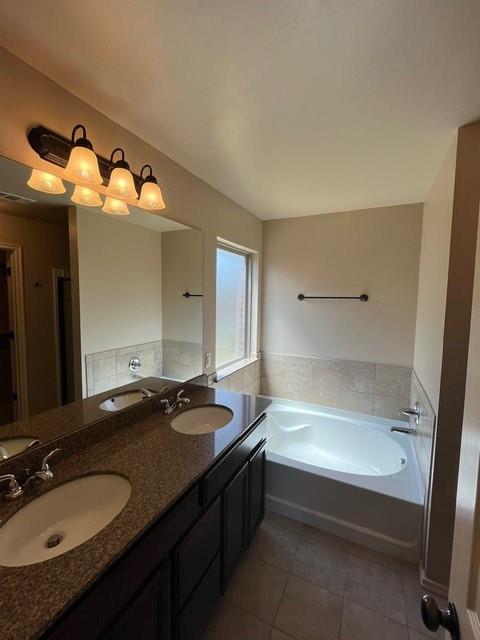 bathroom with tile patterned floors, vanity, and a bath