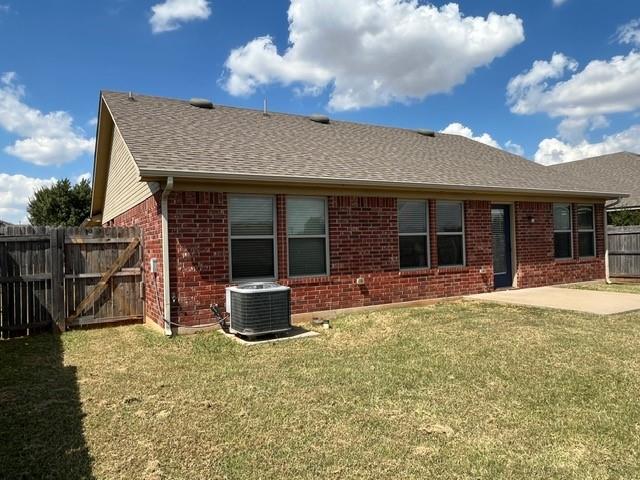 back of property featuring cooling unit, a yard, and a patio