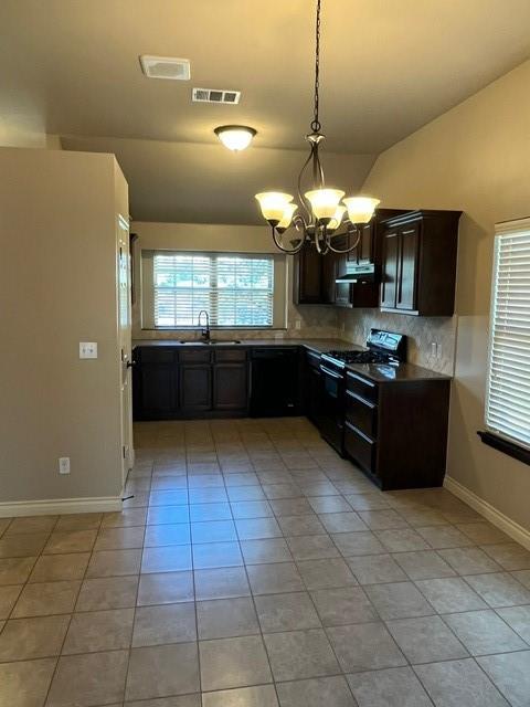 kitchen with tasteful backsplash, black range oven, pendant lighting, a notable chandelier, and lofted ceiling