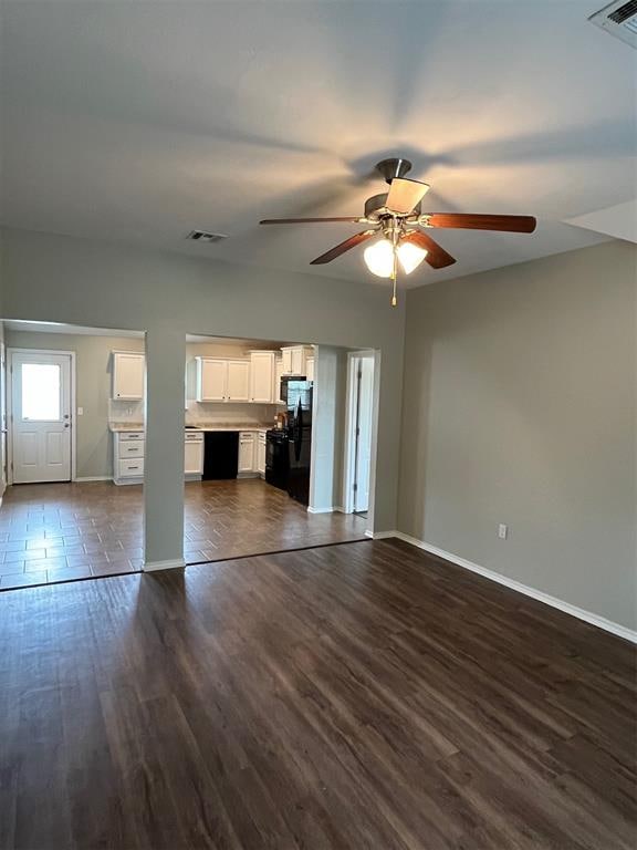 unfurnished living room with ceiling fan and dark wood-type flooring