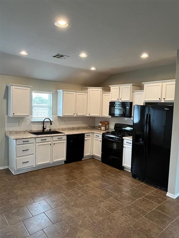 kitchen featuring sink, vaulted ceiling, white cabinetry, and black appliances