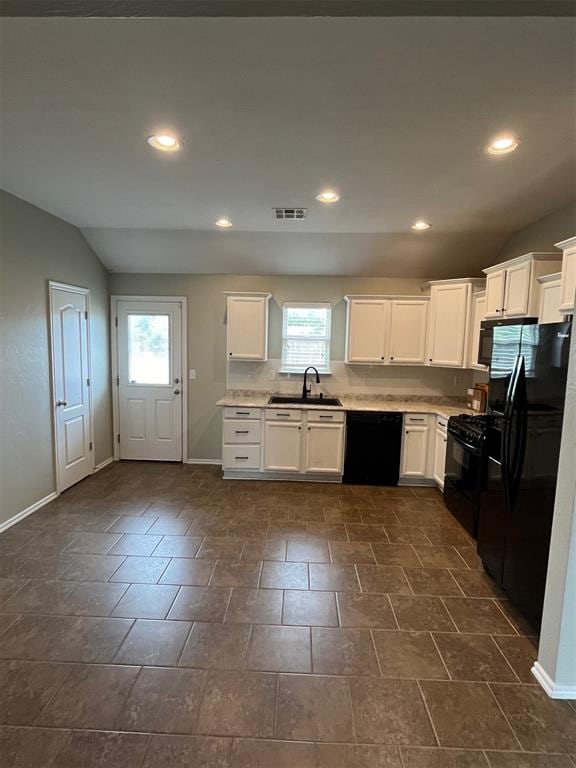 kitchen featuring black appliances, white cabinetry, and a wealth of natural light