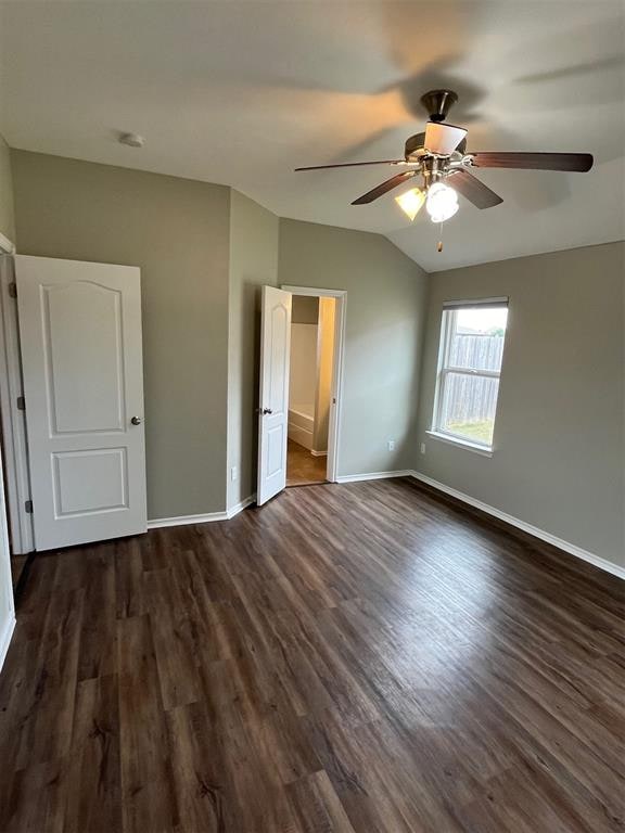 unfurnished bedroom with ceiling fan, dark wood-type flooring, and vaulted ceiling