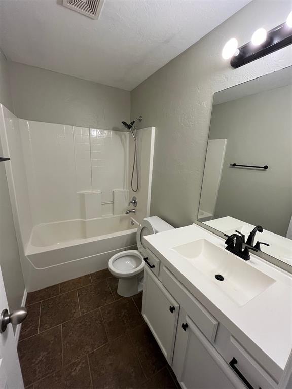 full bathroom with bathing tub / shower combination, vanity, and toilet