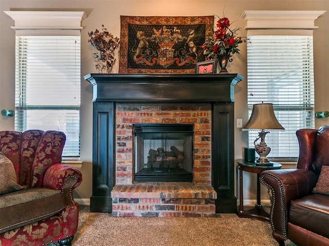 living area featuring carpet flooring, a healthy amount of sunlight, and a brick fireplace