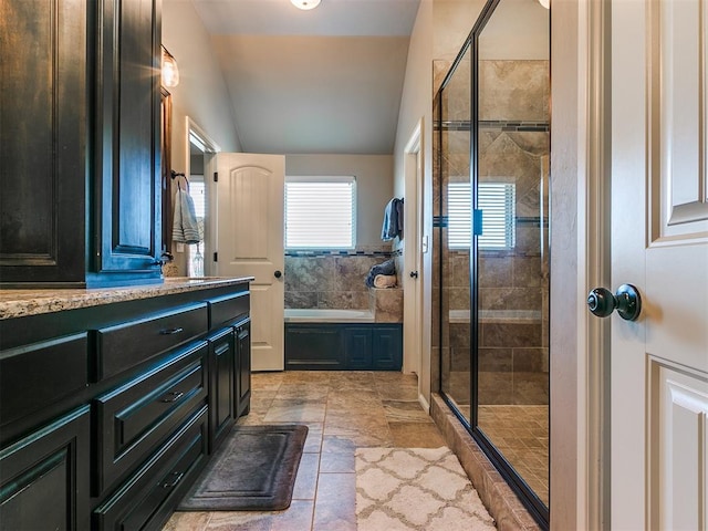 bathroom with vanity, independent shower and bath, and lofted ceiling