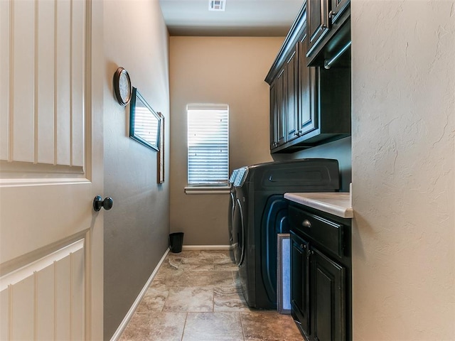 clothes washing area with cabinets and independent washer and dryer