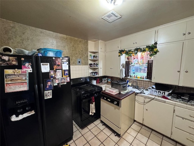 kitchen featuring black appliances, tile counters, and white cabinetry