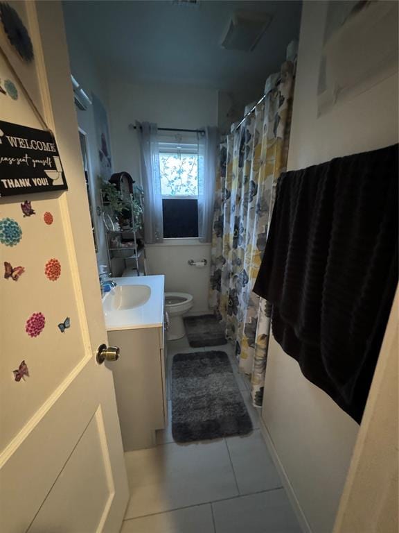 bathroom featuring tile patterned flooring, vanity, and toilet