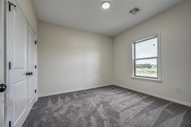 empty room featuring dark carpet