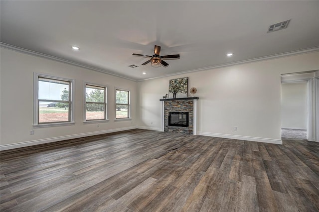 unfurnished living room with a stone fireplace, ceiling fan, dark hardwood / wood-style floors, and ornamental molding