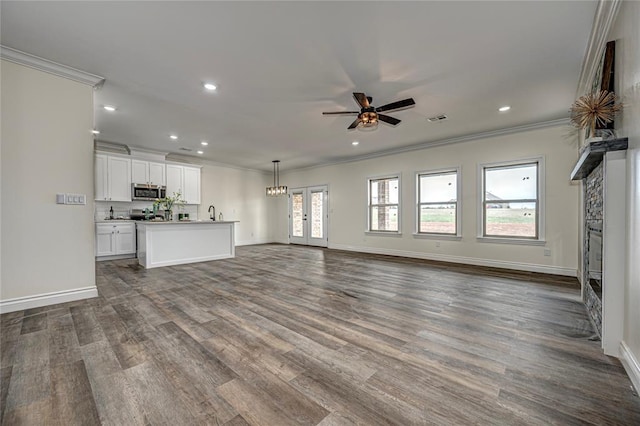 unfurnished living room featuring french doors, sink, crown molding, dark hardwood / wood-style floors, and ceiling fan