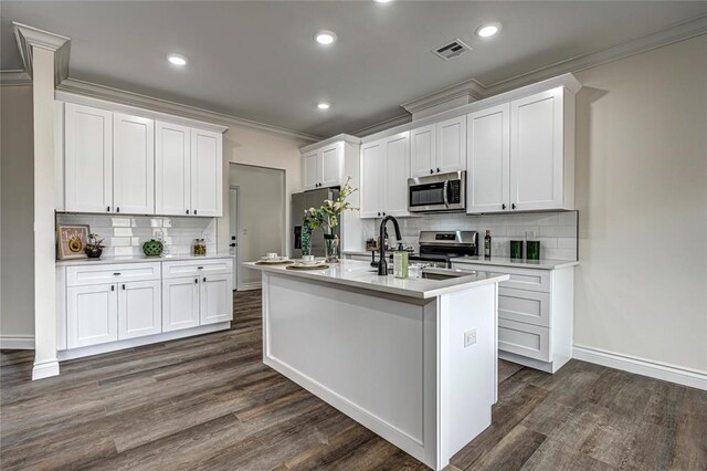 kitchen with white cabinets, a center island with sink, and stainless steel appliances