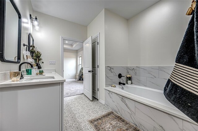 bathroom with vanity and tiled tub