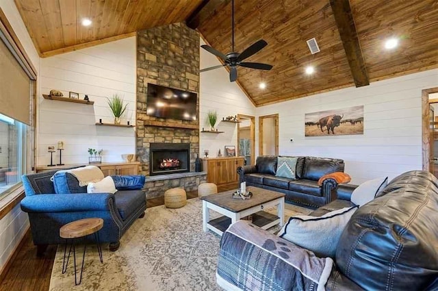 living room featuring wooden ceiling, high vaulted ceiling, a stone fireplace, hardwood / wood-style flooring, and beam ceiling