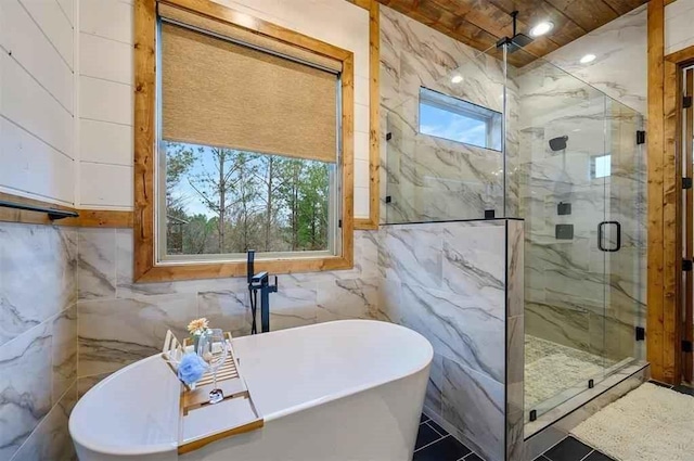 bathroom featuring separate shower and tub, plenty of natural light, and tile walls