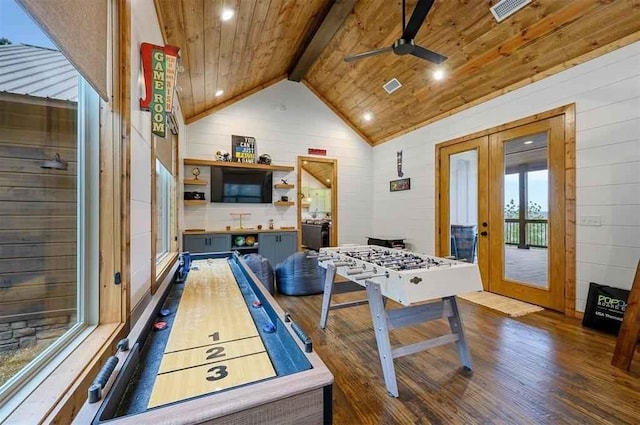 recreation room with french doors, ceiling fan, wooden walls, vaulted ceiling with beams, and dark hardwood / wood-style floors