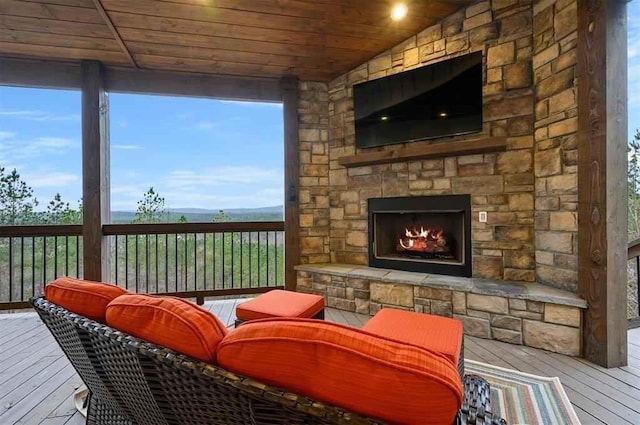 sunroom with lofted ceiling, wood ceiling, and an outdoor stone fireplace