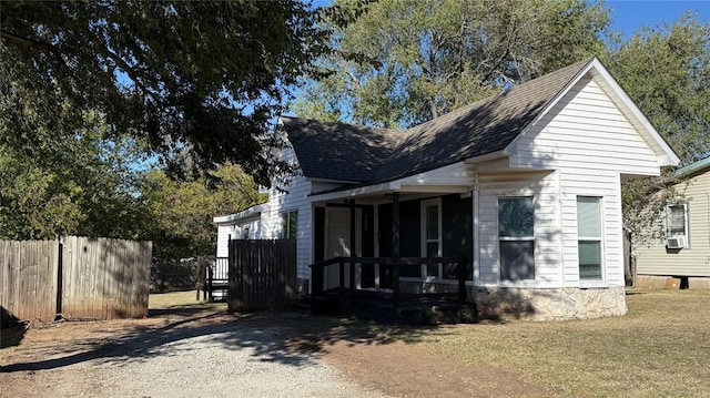 view of front of house with cooling unit and a front lawn