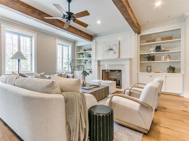 living room with beam ceiling, ceiling fan, plenty of natural light, and light hardwood / wood-style floors