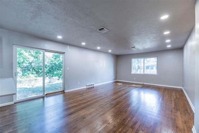 unfurnished room featuring dark hardwood / wood-style flooring and a textured ceiling