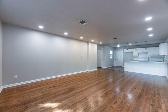 unfurnished living room featuring dark hardwood / wood-style flooring and sink