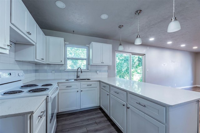 kitchen with kitchen peninsula, sink, white cabinets, and white electric range