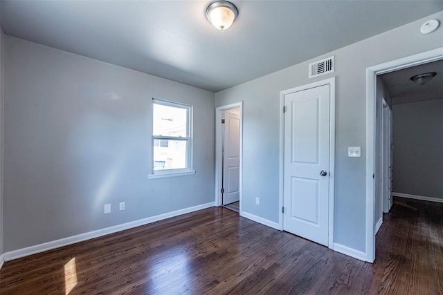 unfurnished bedroom featuring dark hardwood / wood-style flooring