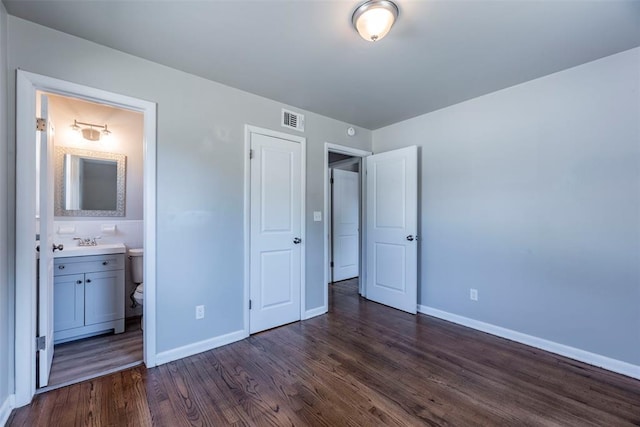 unfurnished bedroom with dark hardwood / wood-style flooring, sink, and connected bathroom