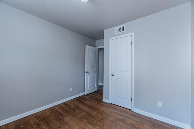 unfurnished bedroom with dark wood-type flooring