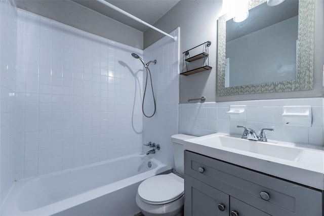 full bathroom featuring toilet, vanity, tile walls, and tiled shower / bath