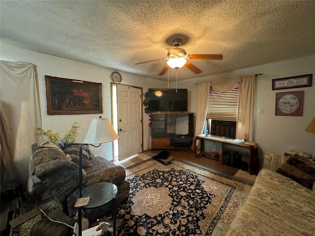 living room featuring ceiling fan and a textured ceiling