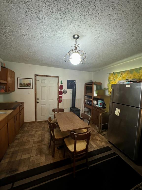 dining area with a textured ceiling and a wood stove