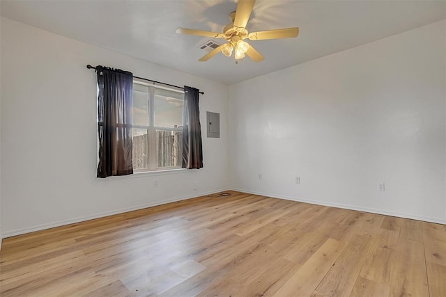 empty room with ceiling fan, electric panel, and light hardwood / wood-style flooring