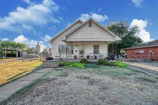 bungalow-style house featuring covered porch and a front yard