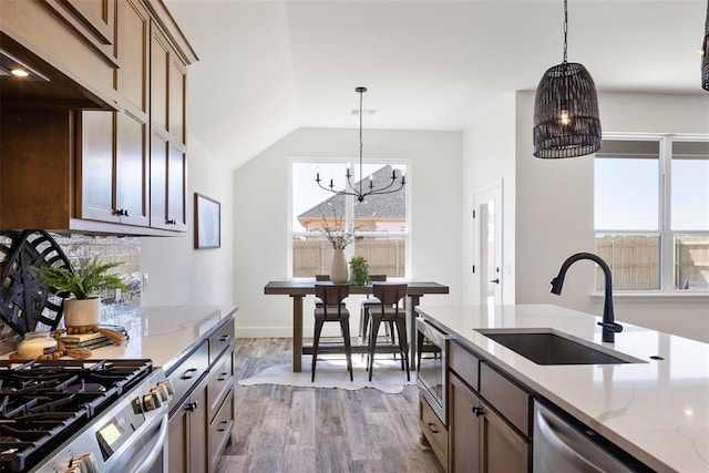 kitchen featuring hardwood / wood-style floors, sink, a healthy amount of sunlight, and a notable chandelier