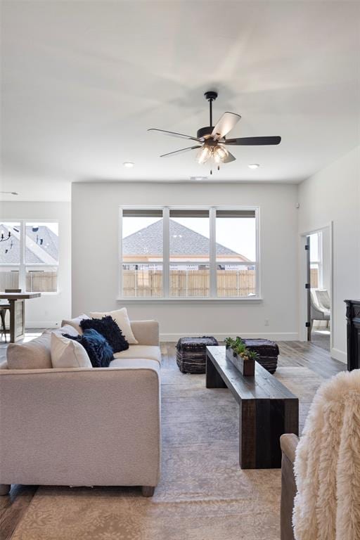 living room featuring ceiling fan and hardwood / wood-style floors