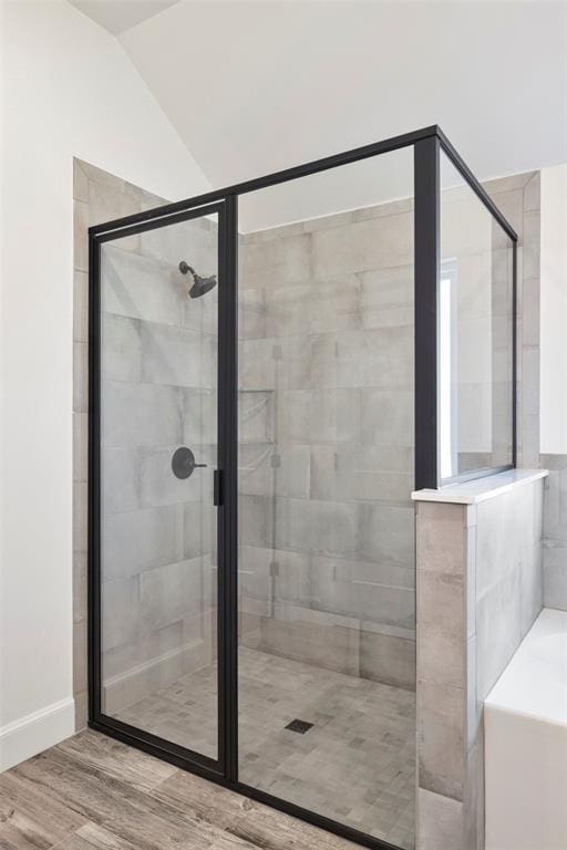 bathroom featuring independent shower and bath, lofted ceiling, and hardwood / wood-style flooring