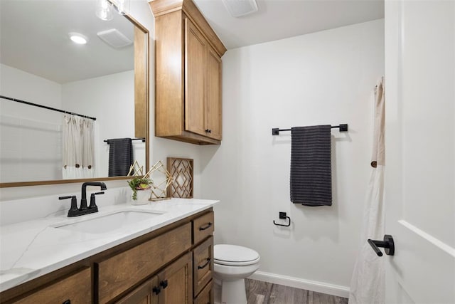 bathroom with vanity, hardwood / wood-style flooring, toilet, and curtained shower